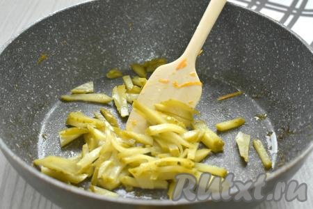 Солёный (или маринованный) огурец нарезаем соломкой, перекладываем в сковороду, в которой жарились овощи, обжариваем 2 минуты, иногда помешивая, затем перекладываем к свинине, морковке и луку.