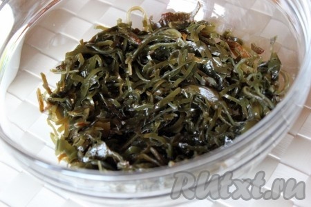 Из банки с морской капустой слить лишнюю жидкость и положить морскую капусту в салатник.