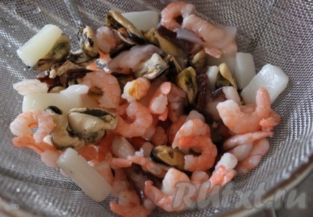 Замороженные морепродукты ополоснуть горячей водой, чтобы убрать с них ледяную глазурь.