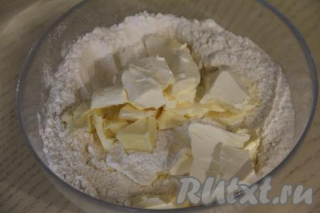 Из холодильника достать сливочное масло, нарезать его на небольшие кусочки, добавить в смесь сухих ингредиентов.&nbsp;