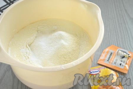 В получившуюся массу просеиваем 100 грамм муки, добавляем разрыхлитель и ванилин, перемешиваем тесто лопаткой до однородности.