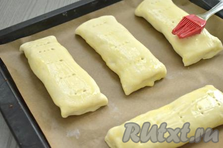 Яйцо в небольшой ёмкости взбиваем вилкой до однородности. Поверхность слоек смазываем взбитым яйцом.