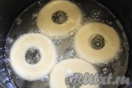 Растительное масло влить в кастрюлю (или в глубокую сковороду), очень хорошо его разогреть, аккуратно выложить несколько заготовок теста. Разогретое масло должно доходить до середины пышек.