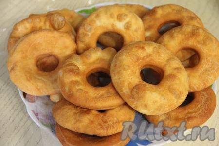 Жареные пышки, приготовленные на ряженке, вначале выкладывать со сковороды на бумажные полотенца, а затем перекладывать на тарелку для подачи. Постепенно пожарить все бездрожжевые пышки. Получается целая тарелка воздушных пышек.