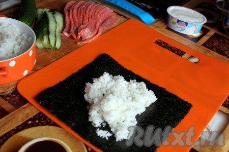 На лист нори выложить тонкий слой риса.