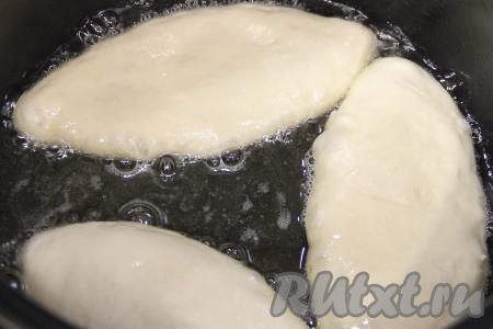 В глубокую сковороду влить достаточно много растительного масло, очень хорошо его разогреть, уменьшить огонь до среднего. Выложить несколько пирожков с начинкой из картошки и яиц швом вниз. Раскалённое масло должно доходить почти до середины пирожков.