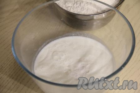 Кефир влить в глубокую миску, добавить соду, хорошо перемешать и оставить на 5 минут. За это время сода погасится в кислой среде кефира и поверхность смеси покроется пузырьками.