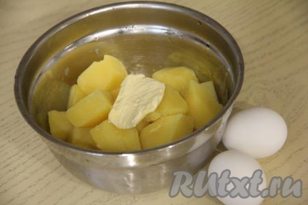Пока тесто для пирожков "отдыхает" при комнатной температуре, подготовим начинку. Для этого яйца нужно сварить вкрутую (в течение 10 минут после начала кипения воды), после этого остудить их и очистить. Очищенный картофель отварить в кастрюле в подсоленной воде до готовности (в течение 20-25 минут с момента закипания воды), затем лишнюю жидкость из кастрюли слить. В кастрюлю с горячей варёной картошкой добавить сливочное масло.