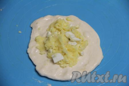 Из каждой части теста на присыпанной мукой поверхности сформировать лепёшку, в центр выложить 1 столовую ложку с горкой картофельно-яичной начинки.&nbsp;