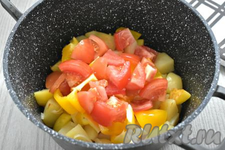 Помидоры тоже нарезаем крупно (по желанию, перед нарезанием помидоров можно снять с них кожуру) и добавляем в казан (или кастрюлю) к остальным ингредиентам.