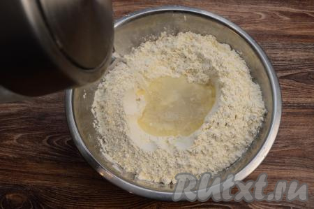 Вскипятить 400 миллилитров воды. Небольшой струйкой влить примерно 100 миллилитров кипятка поверх масла и перемешать столовой ложкой, смешивая с мукой. Перемешивайте очень осторожно, чтобы не обжечься, ведь вода горячая. 