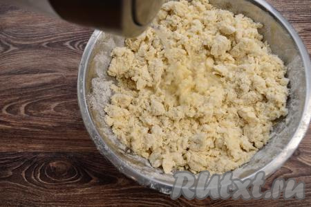 Затем влить ещё немного горячей воды, перемешать столовой ложкой, тесто в процессе смешивания с кипятком немного остынет, начать замешивать его руками, полностью смешивая муку с водой. Таким образом, понемногу вливая горячую воду, перемешивания ложкой, а затем вымешивая руками, продолжить замешивать тесто. Сначала тесто будет напоминать крошку, но по мере добавления понемногу горячей воды и вмешивания её, оно станет уплотняться, собираться в ком. Горячую воду добавляйте постепенно, в этом рецепте консистенцию замешиваемого теста следует регулировать именно добавлением воды. Возможно, вам воды потребуется чуть меньше, чем указано в рецепте - главное ориентируйтесь на консистенцию замешиваемого пельменного теста. Я добавила ровно 400 миллилитров воды, чтобы получить тесто нужной консистенции.