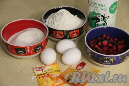Подготовить продукты для приготовления пирога с клюквой в духовке.&nbsp;Кефир можно использовать любой жирности (я взяла жирностью 3,2%). Клюква для этой выпечки подойдёт как свежая, так и замороженная. Свежие ягоды нужно перебрать, промыть водой, а затем обсушить, разложив их на бумажном (или тканевом) полотенце. Замороженную клюкву, если на ней нет большого количества льда, можно не размораживать.