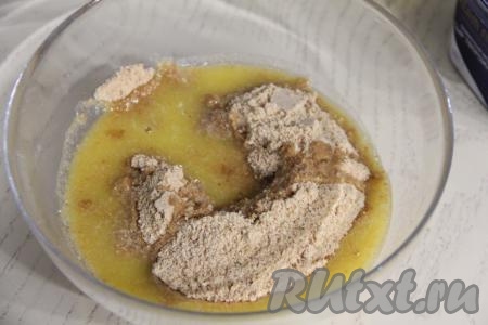 Сливочное масло растопить до жидкого состояния, дать ему немного остыть. В миске соединить растопленное масло и крошку из печенья, перемешать.