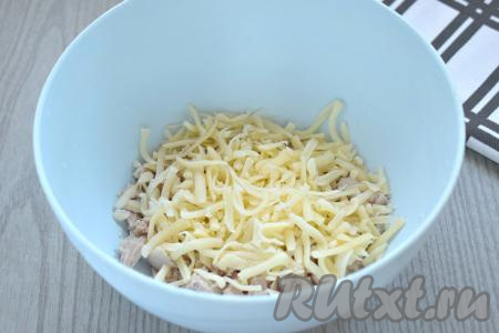 В миску с куриным мясом добавляем сыр, натёртый на крупной тёрке.