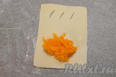 Ближе к стороне, противоположной стороне с надрезами, выложить примерно 1,5 столовых ложки начинки из тыквы и сахара, отступая примерно по 1,5 сантиметра от краёв теста.