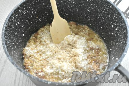 Рис промываем, лишней воде даём стечь. К тушёнке, обжаренной с луком, выкладываем рис, солим, перчим, перемешиваем.