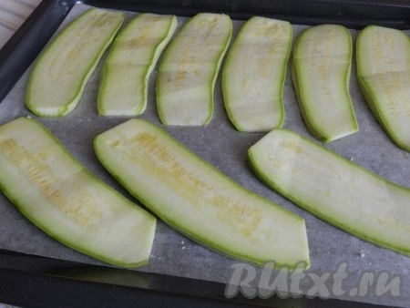 Противень застелить бумагой для выпечки, разложить кабачки, немного смазать оливковым маслом и посолить. Поставить в разогретую до 180 градусов духовку на 5-7 минут, чтобы кабачки стали мягче и лучше сворачивались. Затем достать из духовки и дать немного остыть.