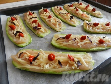 На подготовленные кабачки выложить полоски куриного мяса, присыпать натёртым сыром, мелко нарезанным базиликом, я ещё решила добавить немного покупного неострого соуса из паприки.