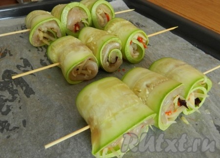 Скрутить кабачки с куриным мясом в рулетики. Нанизать на деревянную шпажку по 3 рулетика, размещая их достаточно плотно друг другу. Отправить противень в духовку, разогретую до 180 градусов, минут на 25.
