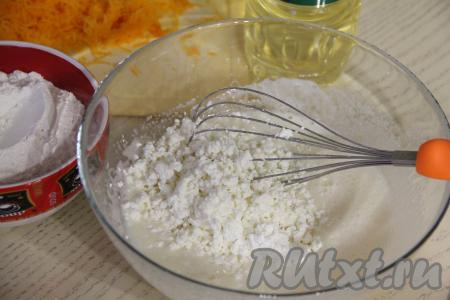 С помощью венчика перемешать яйца с сахаром в течение 3-4 минут (смесь должна немного посветлеть и слегка увеличиться в объёме). В получившуюся смесь добавить растительное масло, творог, перемешать&nbsp;яично-творожную смесь венчиком до однородности.