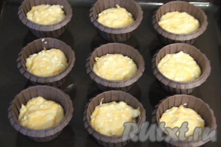 Разложить тесто по формочкам, заполняя их на половину объёма. Я раскладывала тесто по 9 одноразовым бумажным формочкам для кексов, можно выпекать и в силиконовых формочках. Формочки с тестом поставить на противень и отправить в духовку, разогретую до 180 градусов.