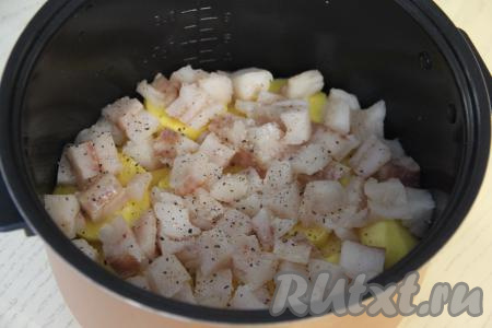 Филе минтая нарезать на кубики размером 2 сантиметра на 2 сантиметра. Выложить кусочки минтая поверх картошки, посолить и добавить немного специй для рыбы. Влить 100 миллилитров воды в чашу.&nbsp;