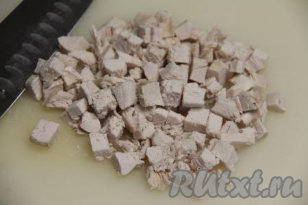 Все ингредиенты для этого салата желательно нарезать на кубики примерно одинакового размера, тогда "Оливье" будет особенно вкусным. Куриное мясо нарезать на средние кубики.