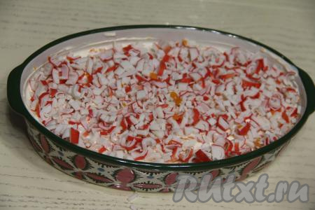 Крабовые палочки вынуть из упаковки, мелко нарезать и выложить равномерно поверх моркови.&nbsp;