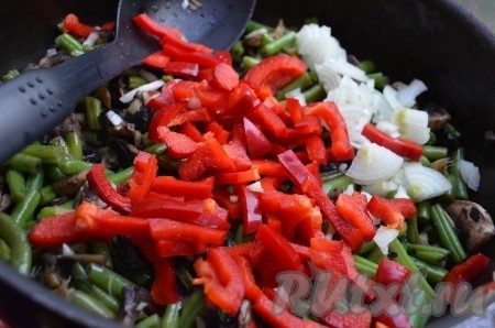 Перец порезать соломкой, лук - полукольцами. Добавить в сковороду имбирь, чеснок, перец и лук. Обжаривать 1-2 минуты.
