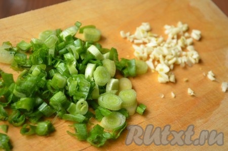 Измельчить чеснок и зеленый лук.