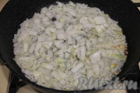 В сковороду влить растительное масло, хорошо разогреть, выложить мелко нарезанный лук. На среднем огне обжарить лук в течение 5 минут (до прозрачности), периодически помешивая.