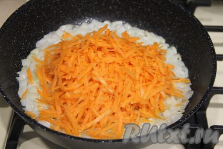 После того как лук обжарится до прозрачности, добавить в сковороду морковку, натёртую на крупной тёрке, сразу перемешать.