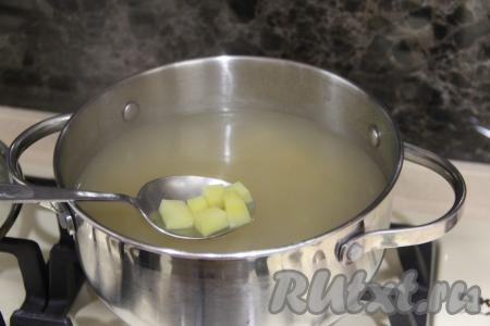 Затем снять кастрюлю с огня, бульон процедить, переложить рыбу в тарелку, луковицу выбросить. Вернуть рыбный бульон в кастрюлю, поставить снова на огонь. В закипевший бульон выложить картофель, нарезанный на кубики, снова дать закипеть и, уменьшив огонь, варить 15 минут.