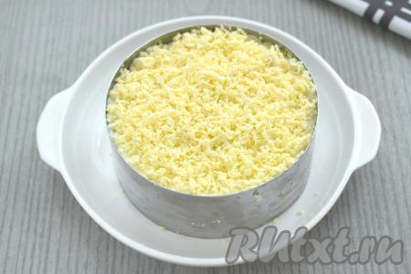 Последним слоем раскладываем по сервировочным кольцам желтки, натёртые на мелкой тёрке. Этот слой салата смазывать майонезом не нужно.