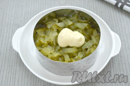 Следующим слоем по формам раскладываем солёный (или маринованный) огурец, нарезанный на тонкие брусочки, разравниваем, смазываем майонезом.