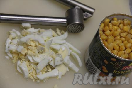 С кукурузы слить жидкость. Яйца очистить и нарезать на небольшие брусочки.