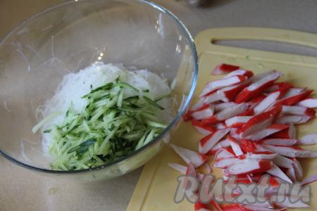 Пока заваривается фунчоза, натереть свежий огурец на тёрке для корейской моркови (или нарезать на тонкие брусочки). Крабовые палочки очистить от слюды и нарезать на длинные бруски.