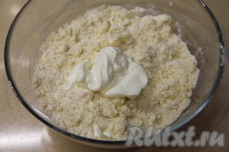 Перетереть содержимое миски руками до получения мелкой, однородной крошки, затем выложить сметану.
