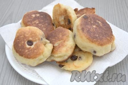 В процессе жарки дрожжевое тесто хорошо поднимается, оладушки становятся пышными. Готовые оладьи с изюмом выкладываем со сковороды на бумажные полотенца, чтобы удалить с них излишки масла. Постепенно жарим все оладьи (у меня вышло 12 штук). Перемешивать тесто перед жаркой очередной порции оладий не нужно.