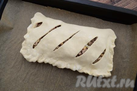 Накрыть начинку стороной с надрезами, хорошо скрепить края теста, сформировав прямоугольный пирог.&nbsp;