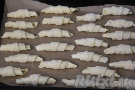 Выложить рогалики с черносливом на противень, застеленный пергаментом. Аналогично сформировать рогалики из второй части теста и теста, которое осталось после того, как&nbsp; подравнивали края раскатанного теста. Всего у меня получилось 24 рогалика.