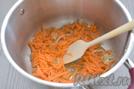 В кастрюлю с обжаренным луком выкладываем морковь, натёртую на крупной тёрке, перемешиваем, обжариваем овощи минут 5 (до мягкости морковки), иногда помешивая.
