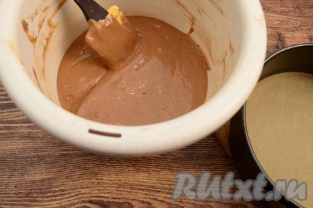 Постепенно подсыпая оставшуюся муку и полностью вмешивая её лопаткой, замесить бисквитное шоколадное тесто, напоминающее по консистенции сметану средней густоты. Старайтесь во время замеса не сбить воздушность взбитых желтков. Как только добились нужной густоты теста, значит больше не нужно добавлять муку.