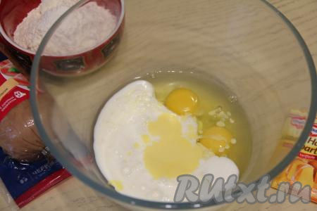 В объёмной миске соединить кефир, сырые яйца, растопленное остывшее сливочное масло, перемешать массу вилкой до однородности.