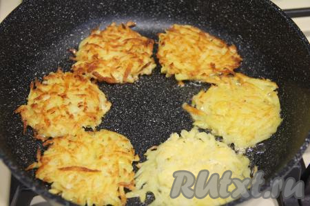 Жарить картофельные драники на среднем огне с двух сторон до золотистого цвета. Драники снаружи должны покрыться хрустящей корочкой снаружи и при этом стать достаточно мягкими внутри. Готовые драники переложить на тарелку. Постепенно пожарить все драники.