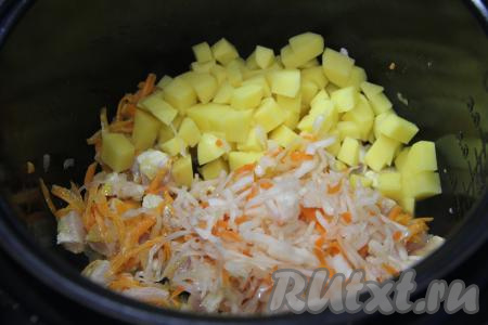 Затем в чашу мультиварки добавить картошку, нарезанную на средние кубики, и квашеную капусту.