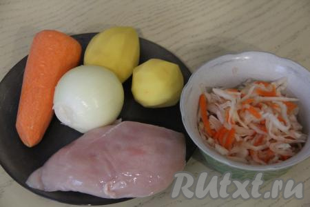 Подготовить продукты для приготовления щей из квашеной капусты с курицей в мультиварке. Картошку, лук и морковь почистить. Картошку выложить в достаточно глубокую ёмкость, полностью залить водой, чтобы она не потемнела. Куриное филе промыть водой.