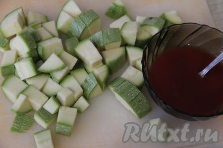 В отдельной ёмкости соединить томатную пасту и 100 миллилитров воды, тщательно перемешать получившийся томатный соус. Кабачок вымыть. Если у кабачка крупные семечки и толстая кожура, тогда кабачок нужно будет очистить и от семян, и от кожуры. У меня был кабачок с мелкими семечками и тоненькой кожурой, поэтому я не стала очищать его от кожуры. 400 грамм подготовленного кабачка нарезать на средние кубики.
