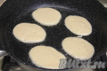 Очень хорошо прогреть сковороду, смазанную растительным маслом, затем выкладывать по 1 столовой ложке теста в виде круглых оладий.